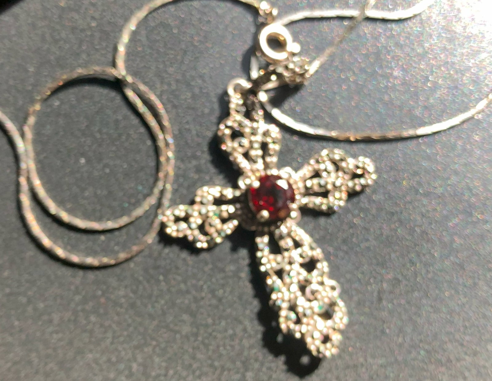 Silver Cross Necklace: Elegant silver cross necklace with a garnet centerpiece.