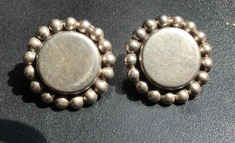 pair of silver round earings with edge decorations