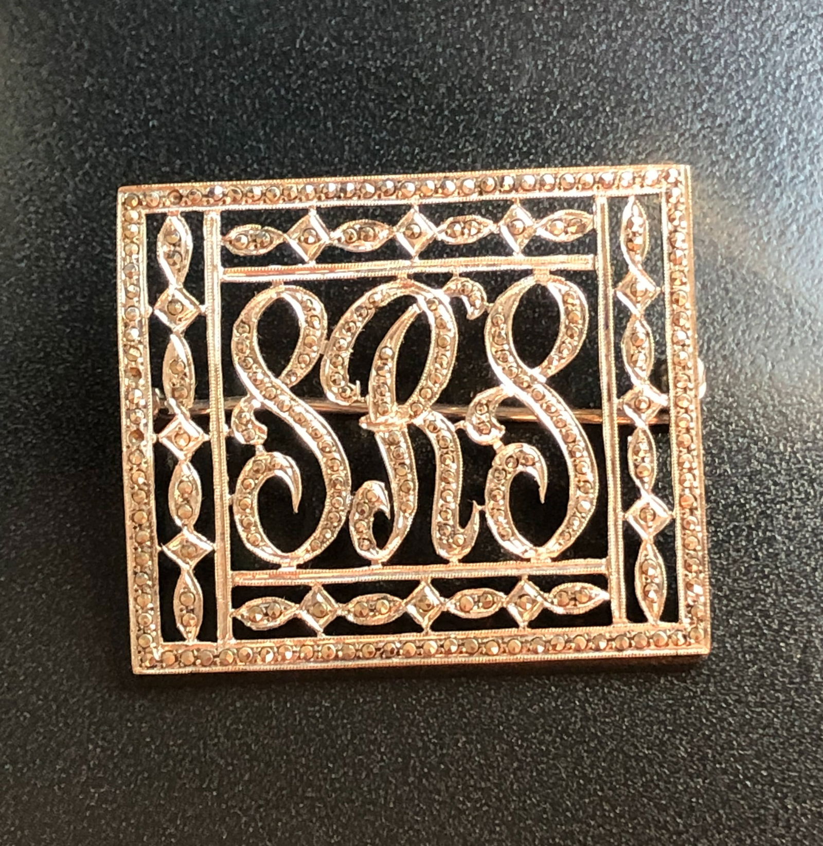 Silver Monogram Brooch: Elegant silver brooch with intricate monogram design. Size: 2".