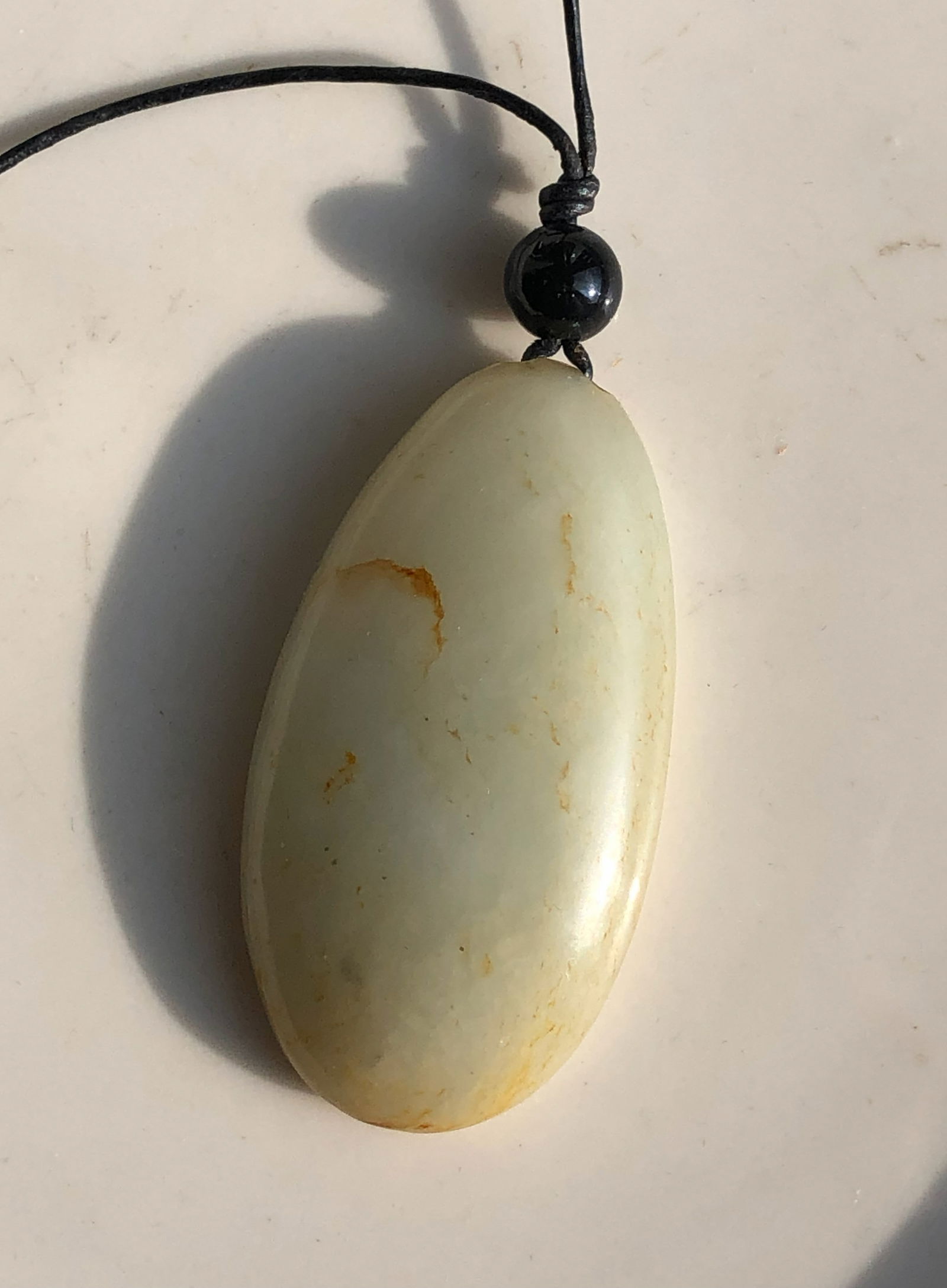 Jade Pendant Necklace: A beautiful jade pendant necklace with a black cord.