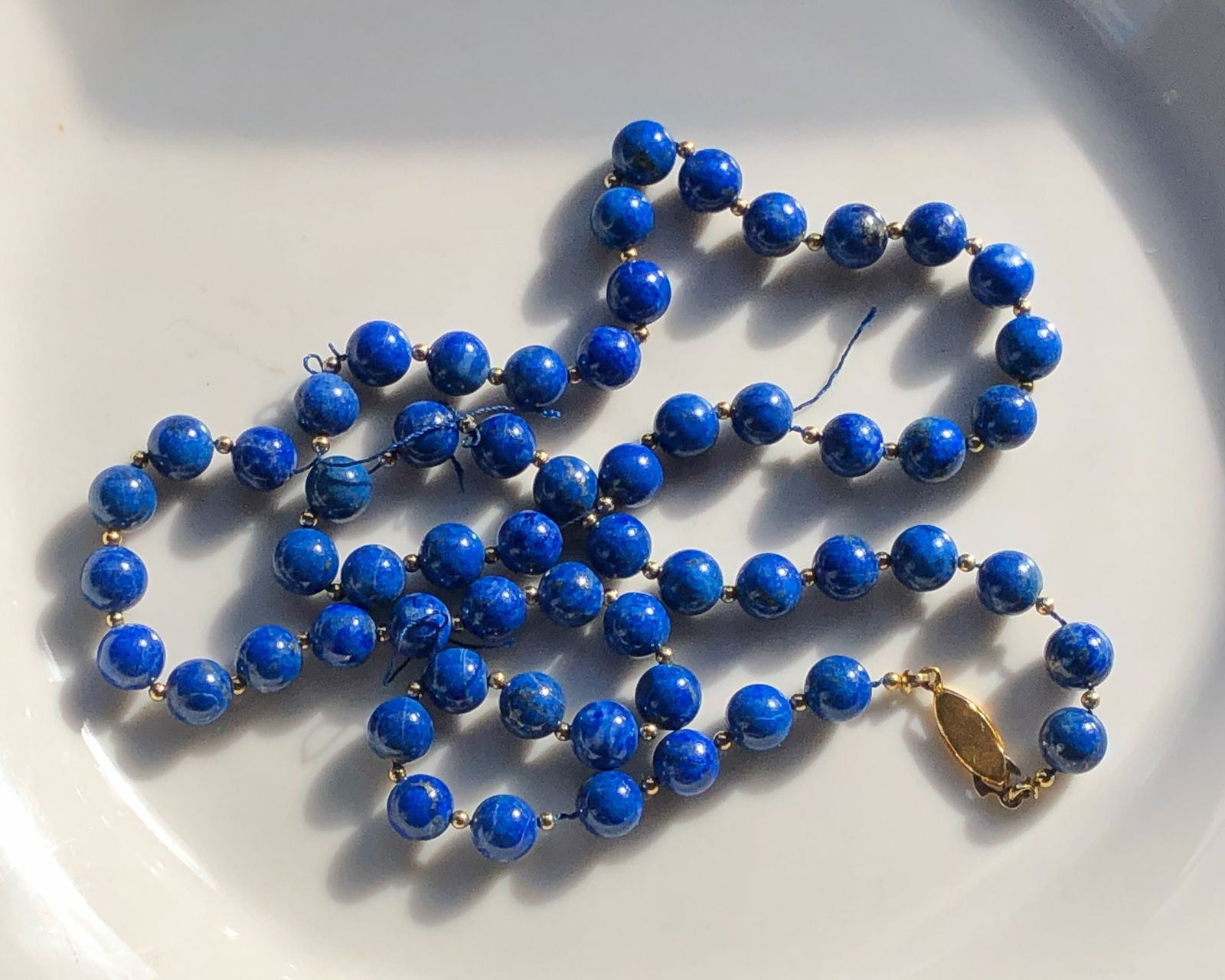 Blue Lapis Beaded Necklace: A beautiful blue lapis beaded necklace with a gold clasp.