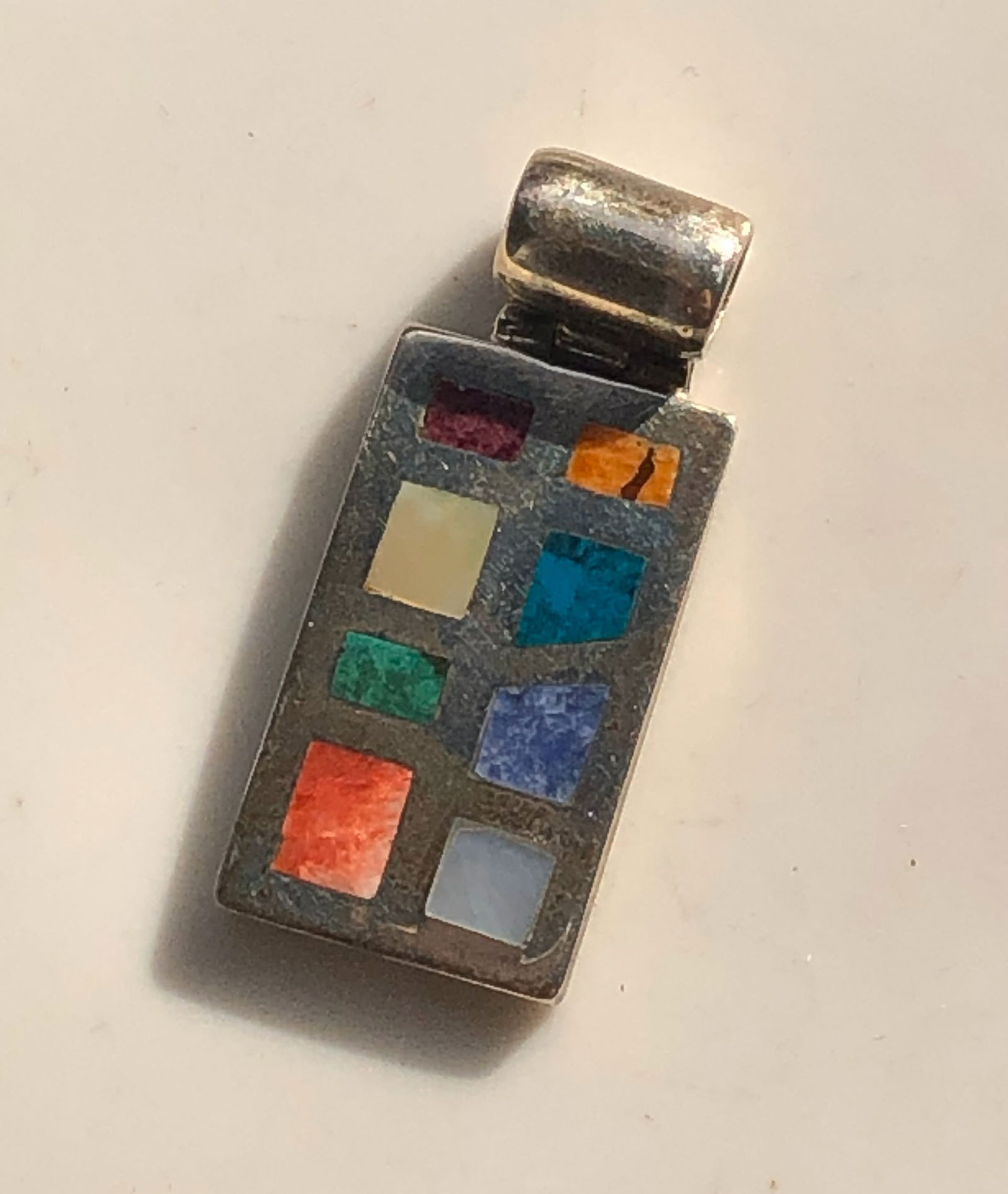 Multicolor Stone Silver Pendant: A unique silver pendant featuring a variety of colorful stones set in a rectangular design.