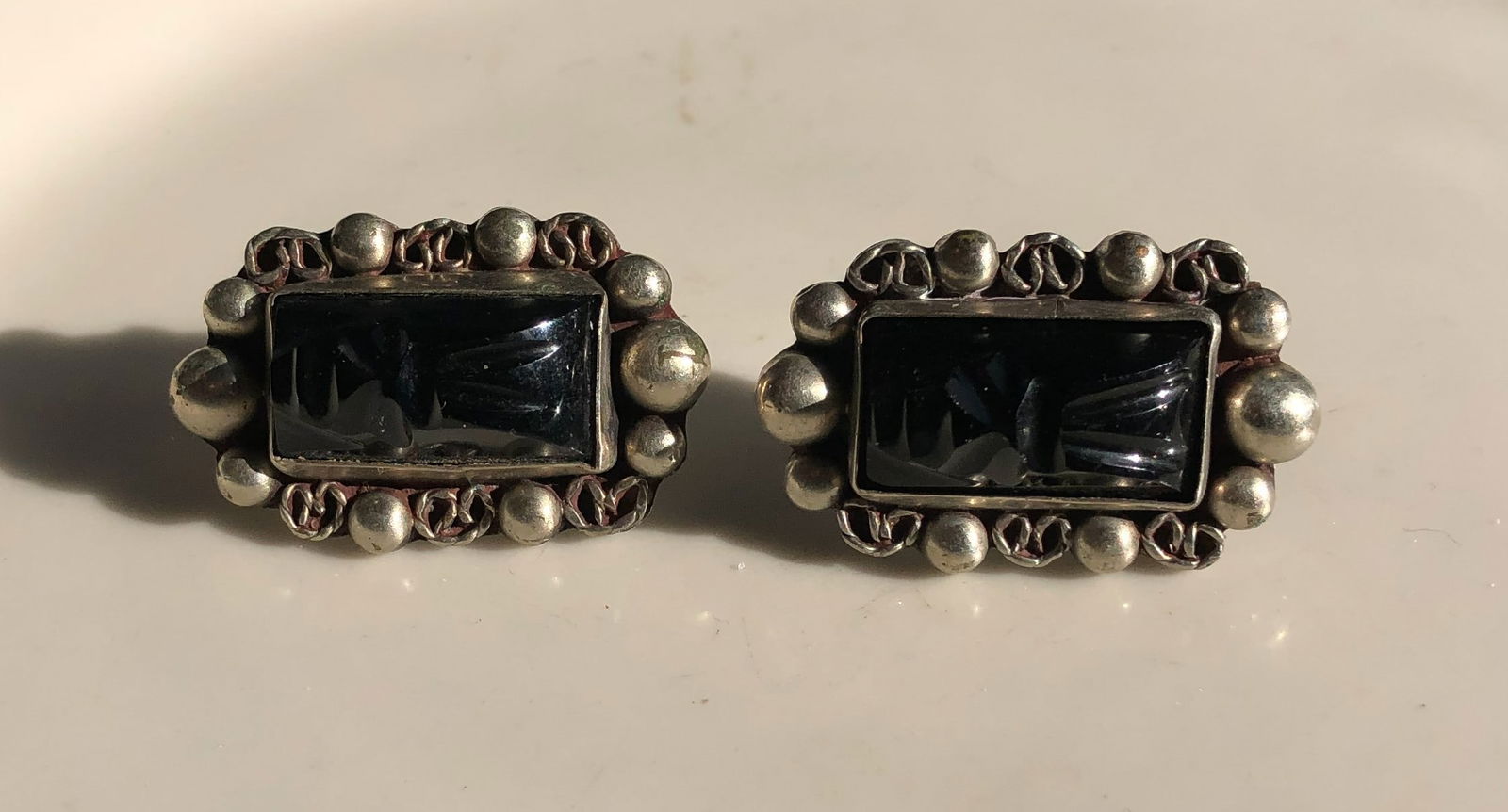 Vintage Earrings: Elegant vintage earrings with intricate design and dark stone centerpiece.