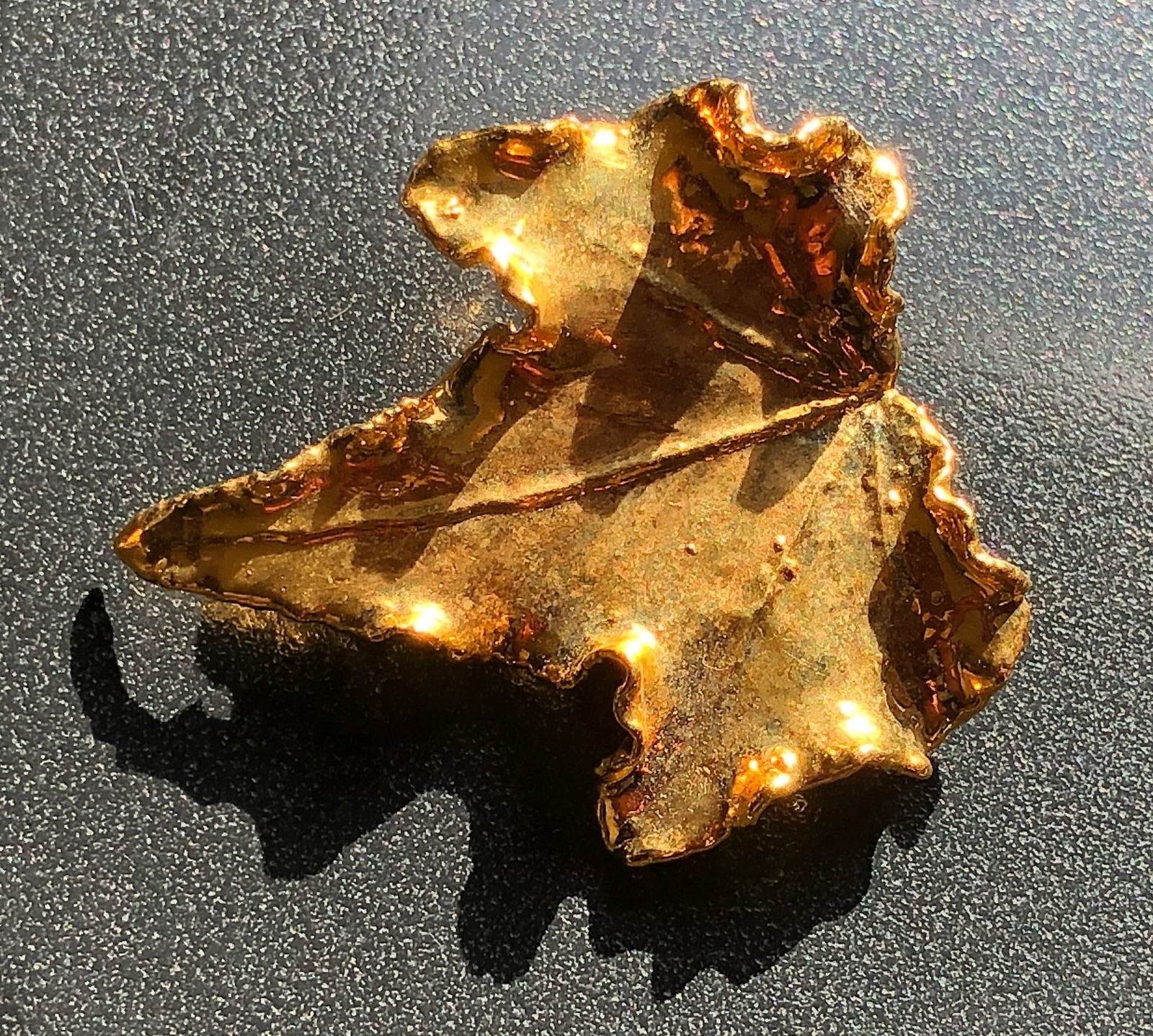 Gold Color Brooch Pin: A unique and Gold Color Brooch Pin with a leaf-like shape.