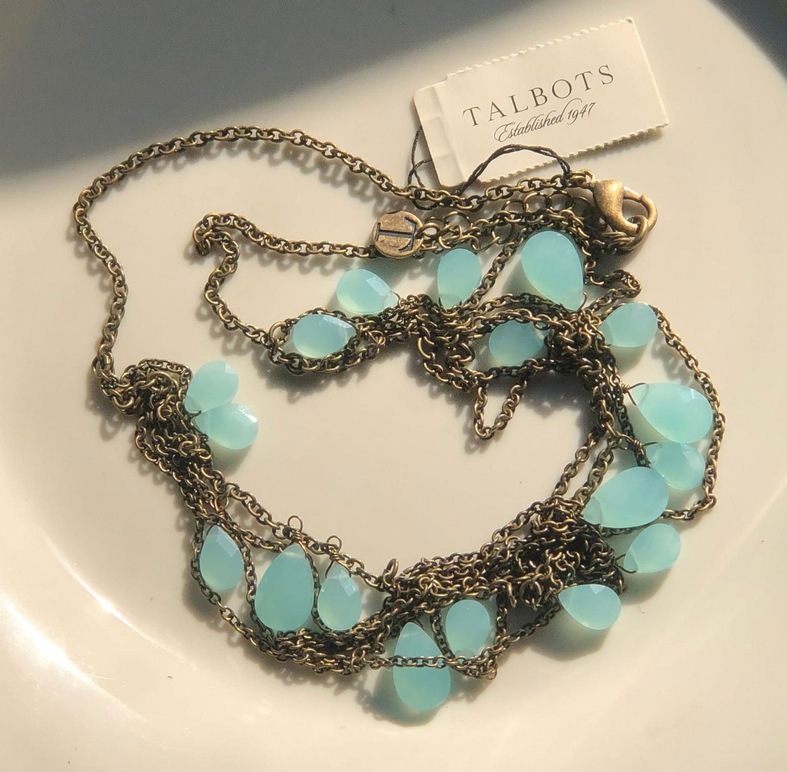 Talbots Necklace: A stylish necklace with blue gemstones and a gold chain.