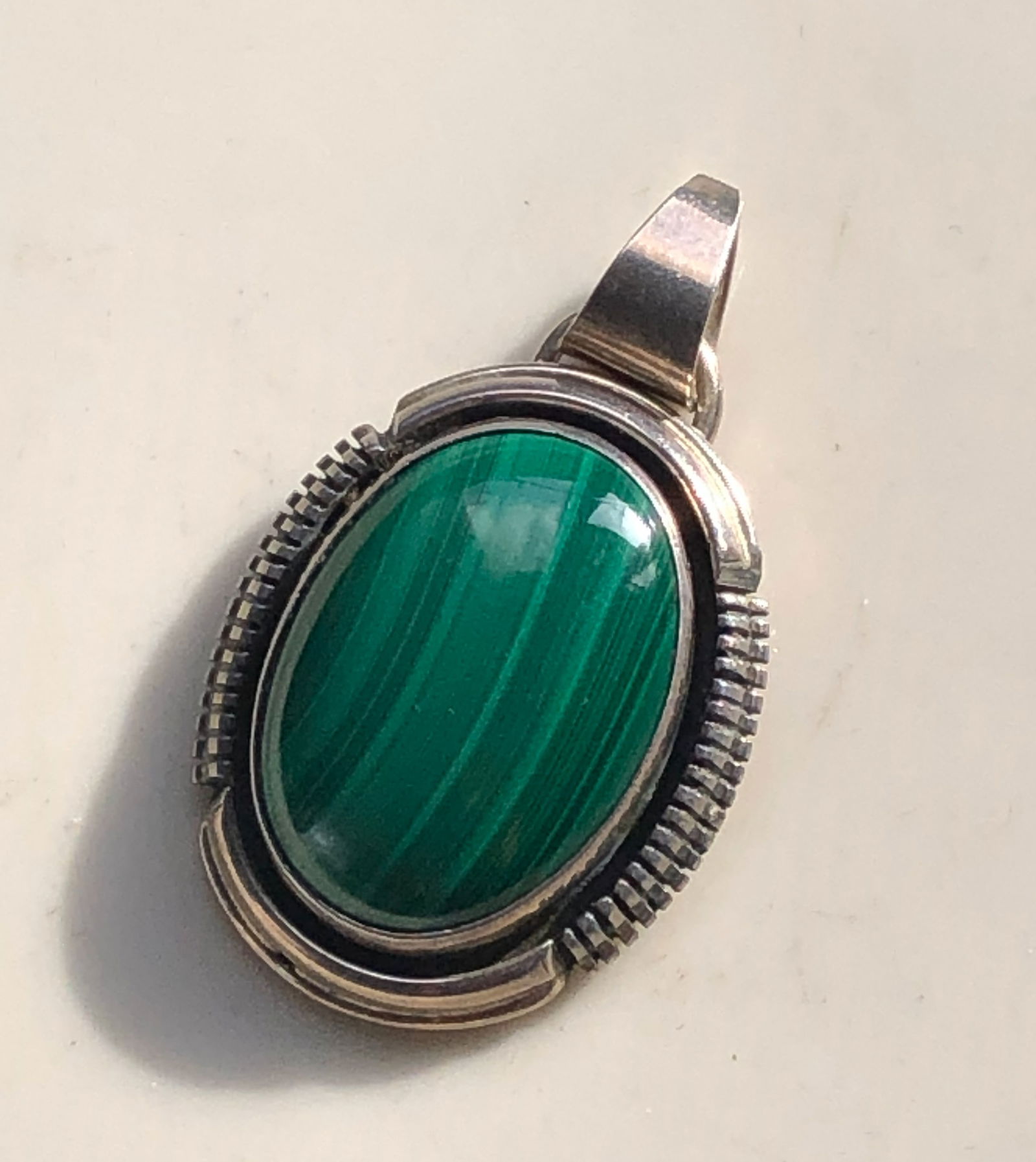 Green Stone Silver Pendant: A beautiful pendant featuring a polished green stone set in a silver frame.