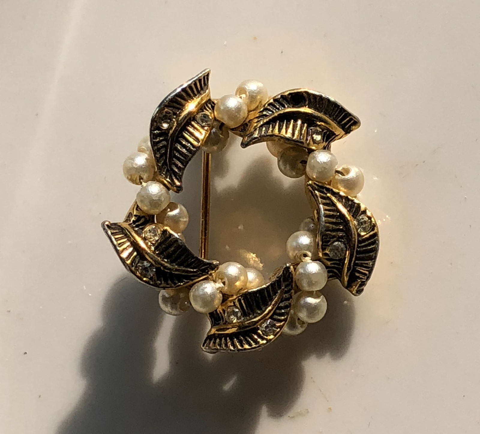 Vintage Leaf and Pearl Brooch: A beautiful vintage brooch featuring intricate leaf designs and elegant pearls.