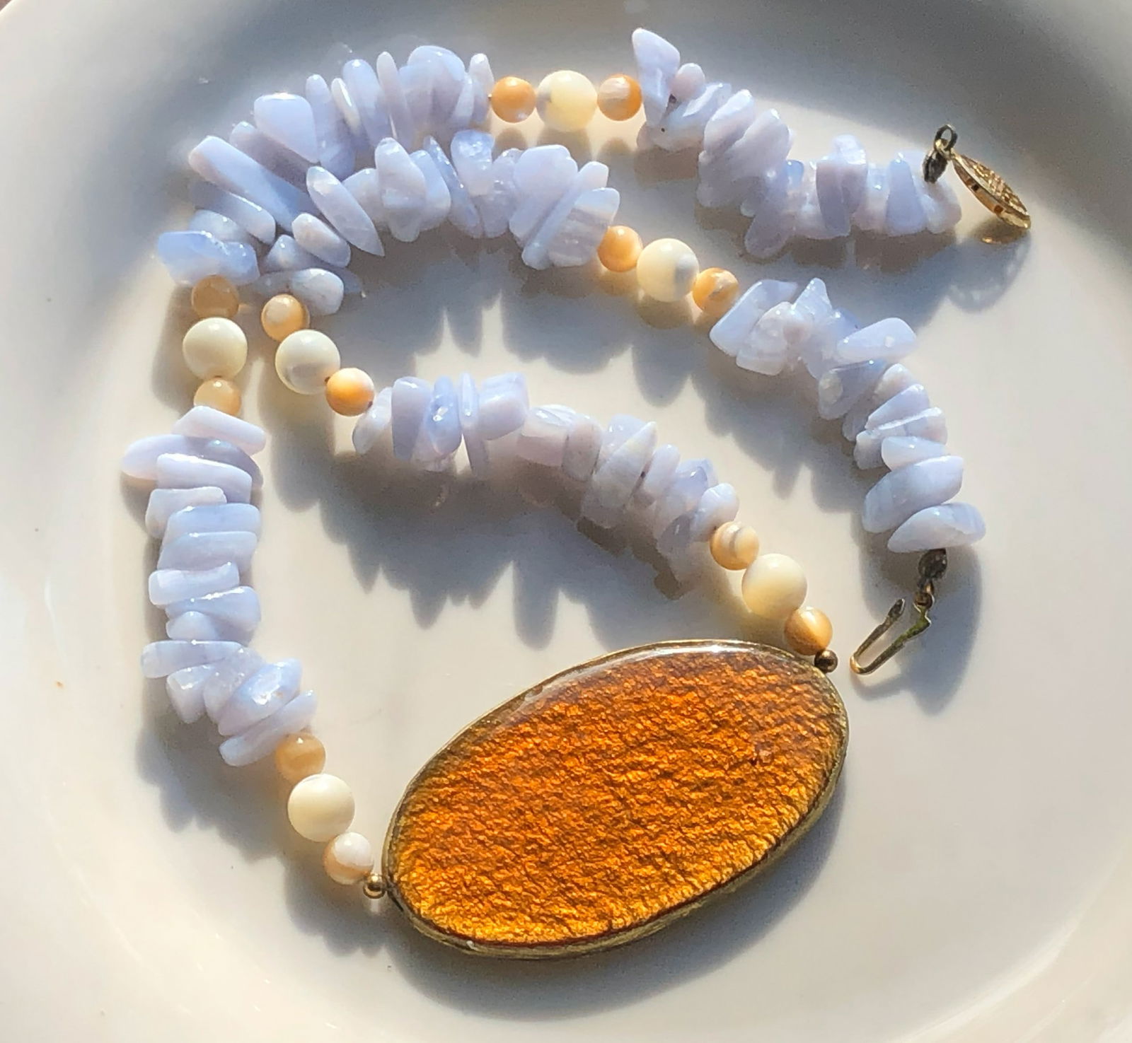 Blue Stone Necklace: A beautiful necklace featuring blue stones and a large amber pendant.