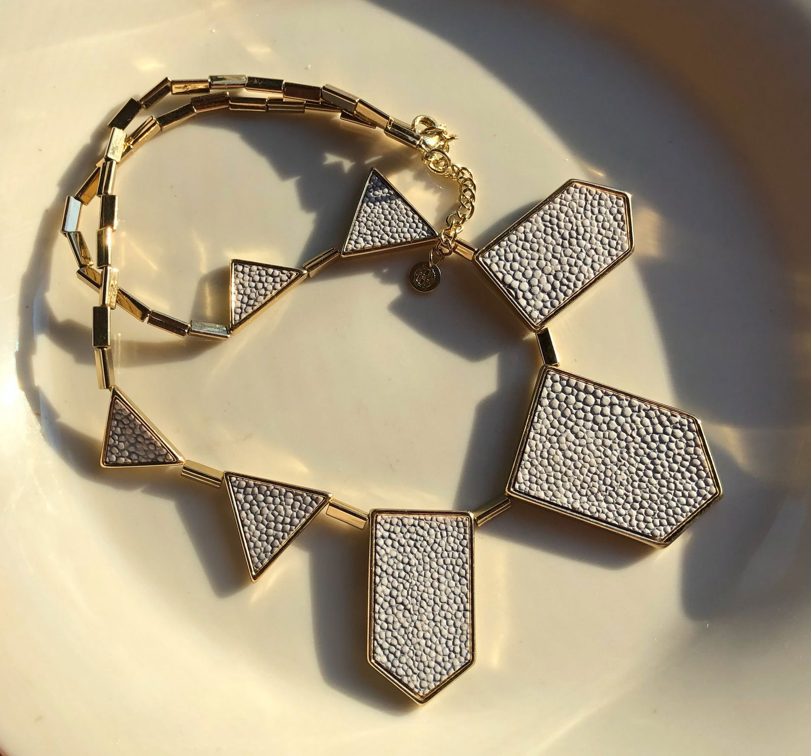 Geometric Gold Color Necklace: A stylish geometric gold Color necklace with textured patterns.
