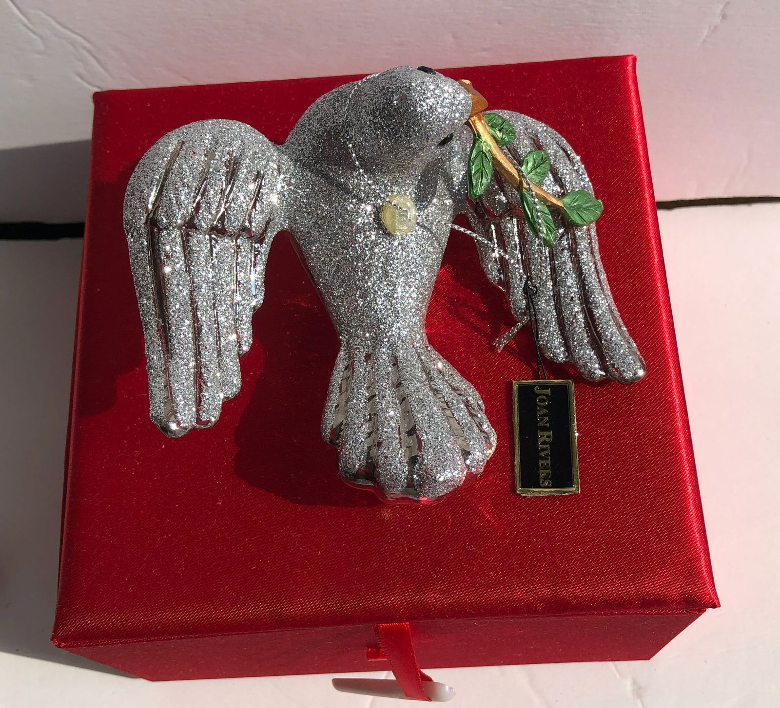 Joan Rivers Silver Glitter Dove Ornament: A Joan Rivers sparkling silver dove ornament with a branch, perfect for holiday decoration.