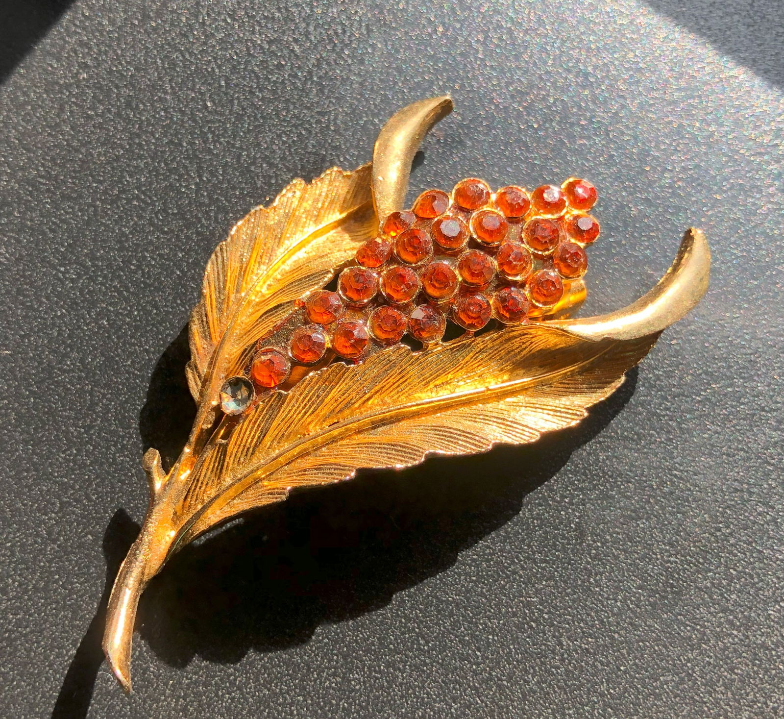 Vintage Gold Color Leaf Brooch: A beautiful vintage brooch with gold Color leaf design and red gemstones.