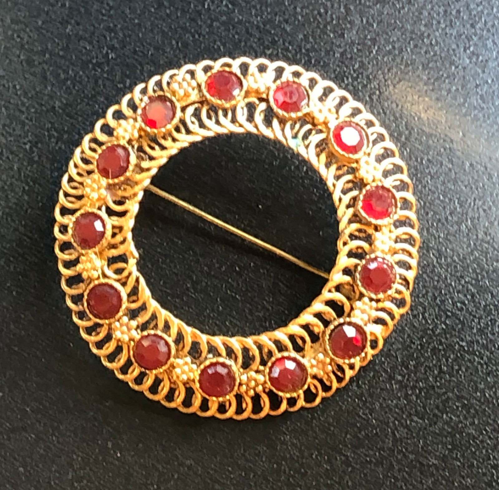 Gold Filled Brooch: A beautiful gold filled brooch adorned with red stones.