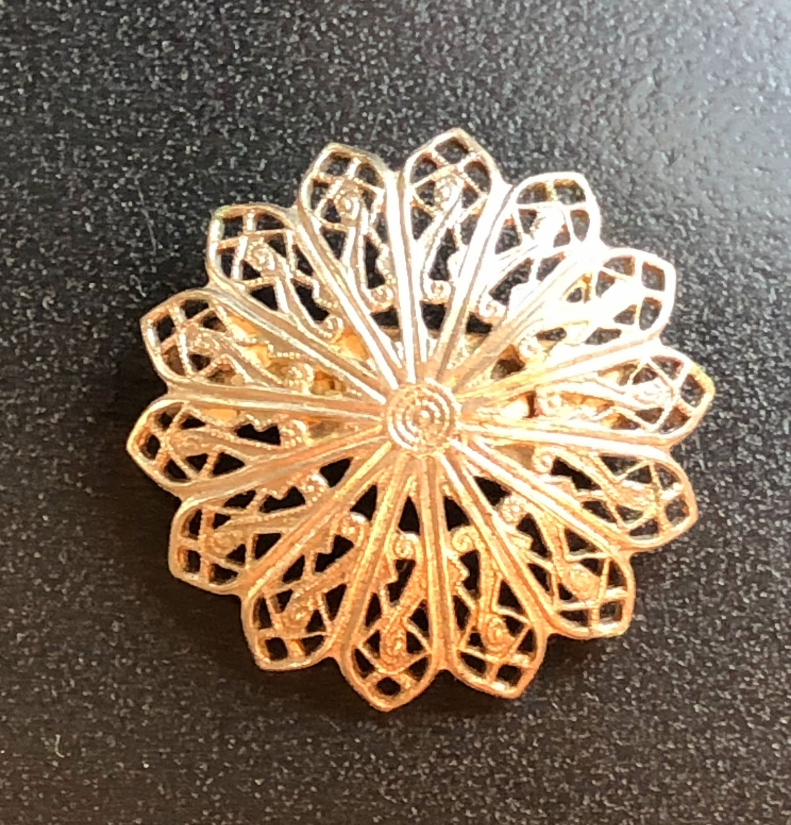 Vintage Filigree Brooch: A beautifully crafted gold filigree brooch with intricate detailing.