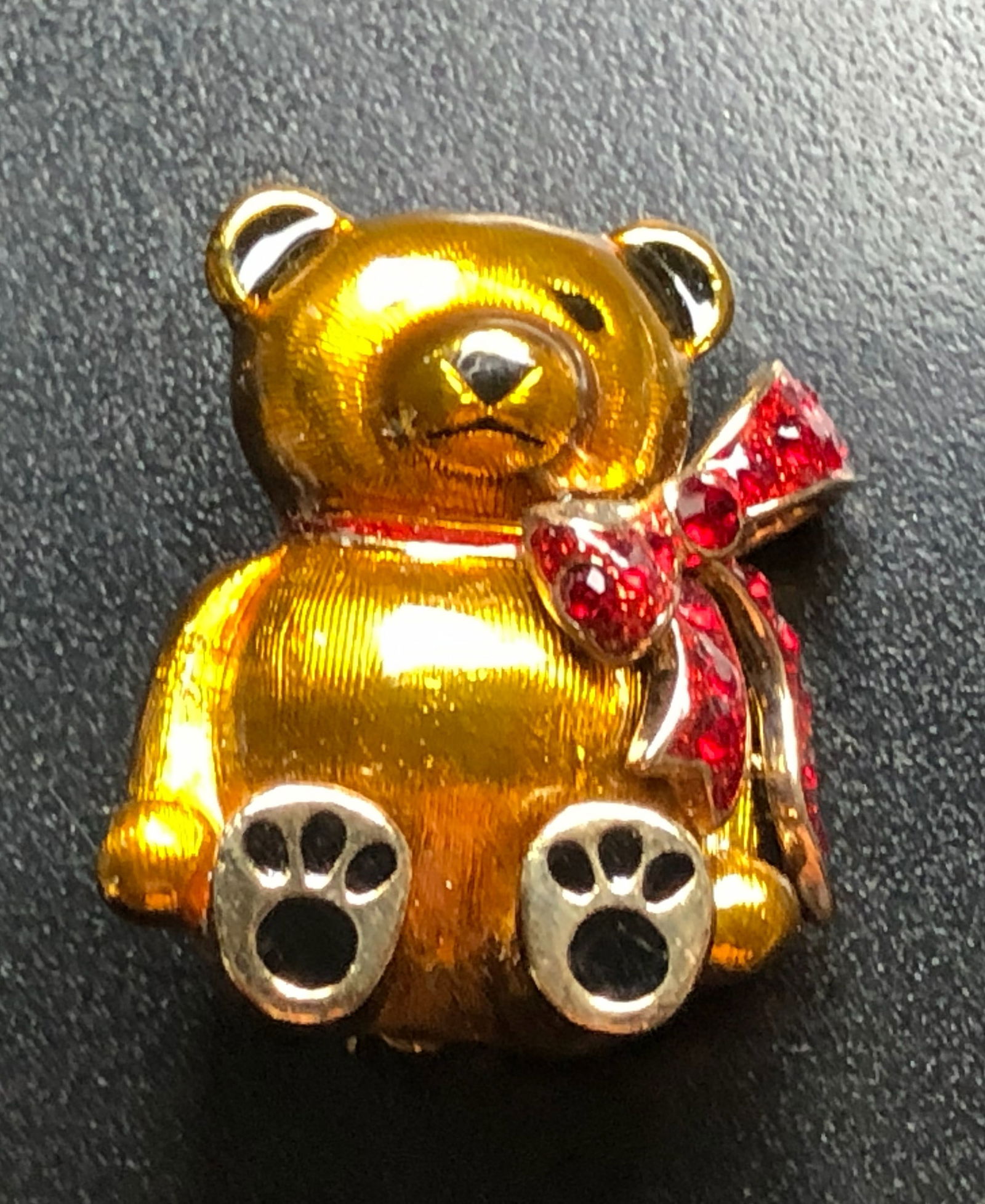 Golden Teddy Bear Brooch: A charming golden teddy bear brooch with red gemstone accents.