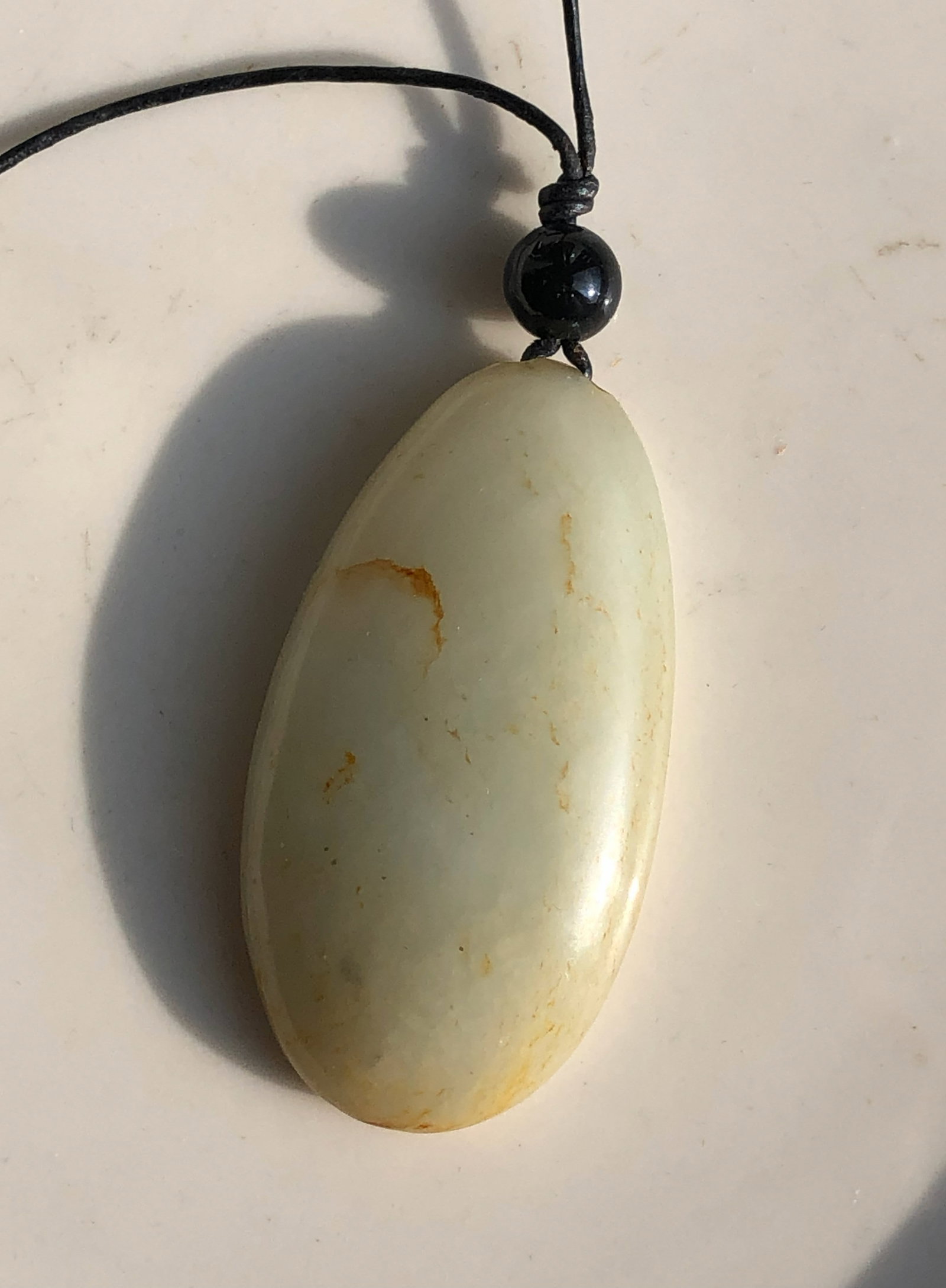Jade Pendant Necklace: A beautiful jade pendant necklace with a black cord.