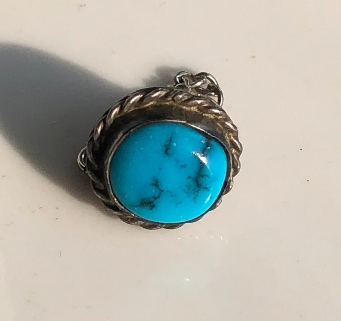 Turquoise Silver Pin: A beautiful turquoise pendant set in a silver frame.