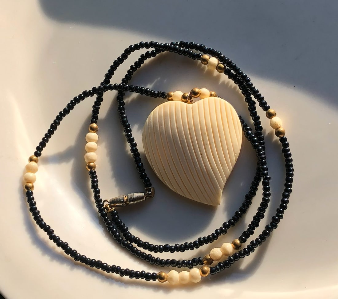 Heart Pendant Necklace: A beautiful heart-shaped pendant necklace with black and gold color beads.