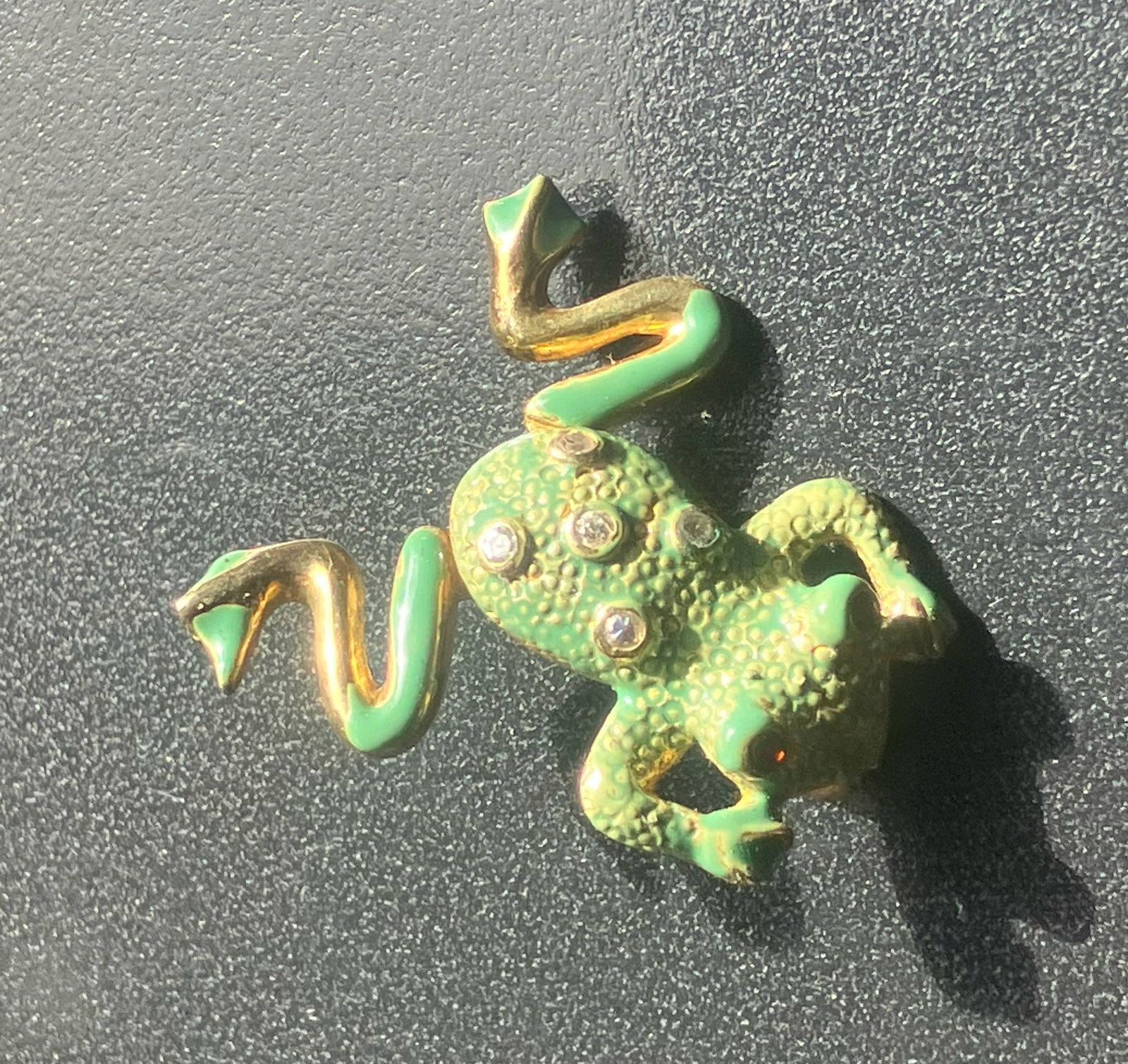 Silver Frog Brooch: A charming Silver frog-shaped brooch with green and gold accents.