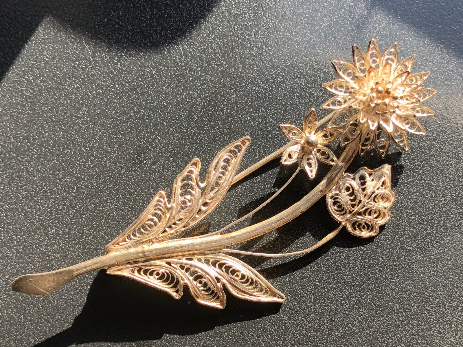 Silver Filigree Flower Brooch: A delicate silver filigree brooch in the shape of a flower, perfect for adding elegance to any outfit. Size: 2.75".