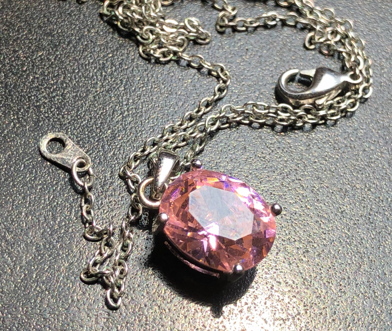 A beautiful necklace featuring a pink gemstone set in a silver color chain: A beautiful necklace featuring a pink gemstone set in a silver color chain