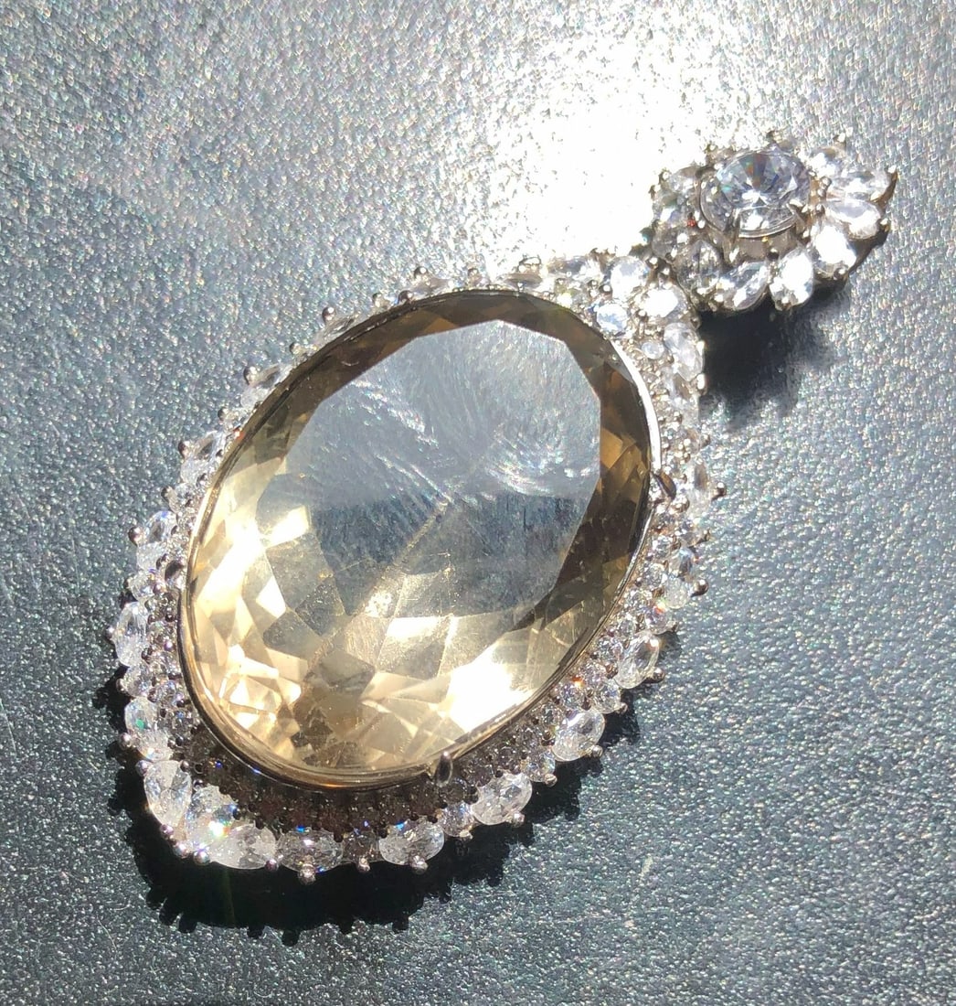 Elegant Silver Citrine Pendant: A stunning Citrine silver pendant with a large central stone surrounded by smaller sparkling gems. Size: 2" x 1"