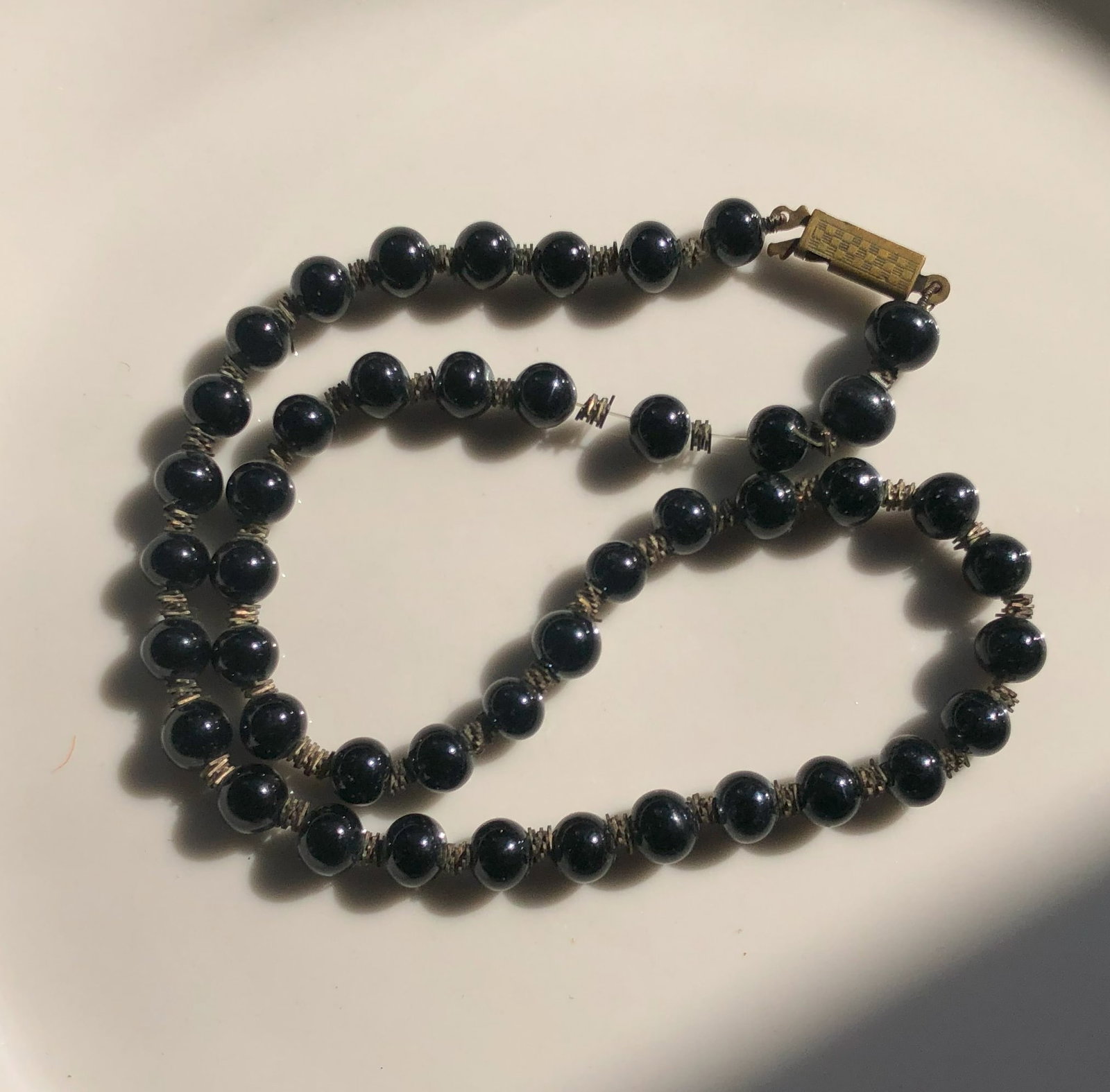Black Beaded Necklace: Elegant black beaded necklace with a classic clasp.