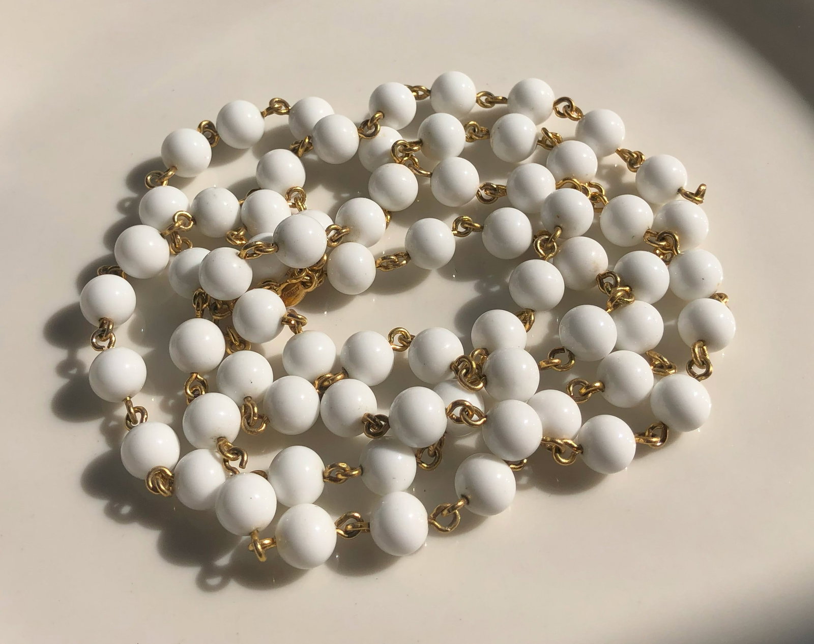 White Beaded Necklace: Elegant white beaded necklace with gold Color links.