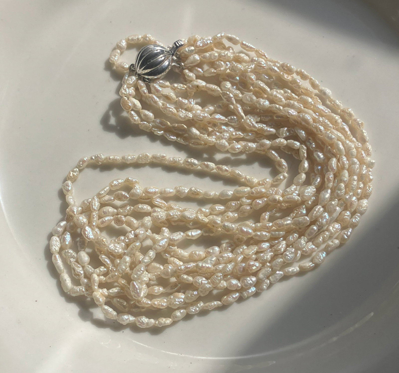 Pearl Necklace with Silver Clasp: Elegant multi-strand pearl necklace with a silver clasp.