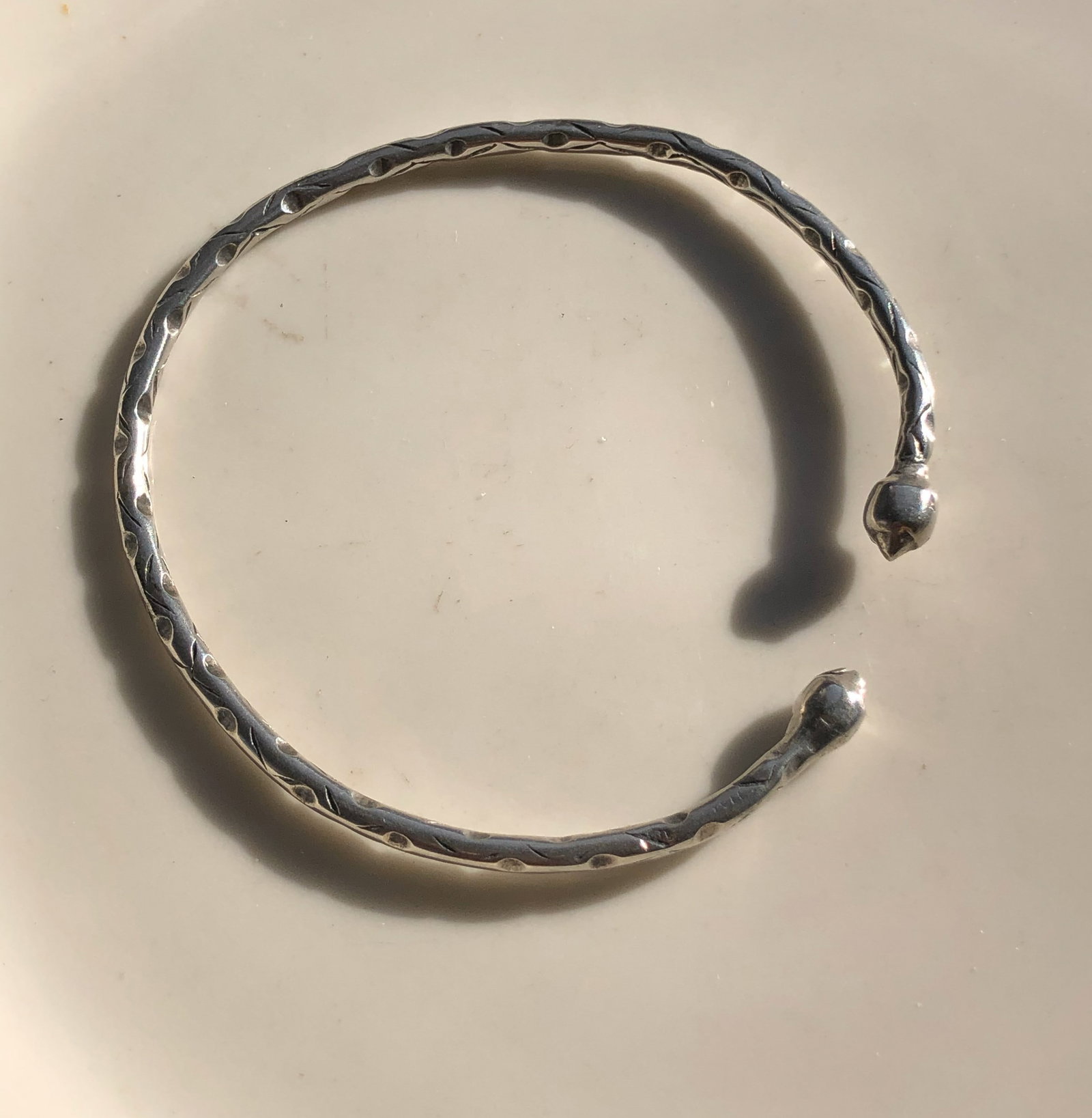 Silver Bangle Bracelet: Elegant silver bangle bracelet with a textured design.
