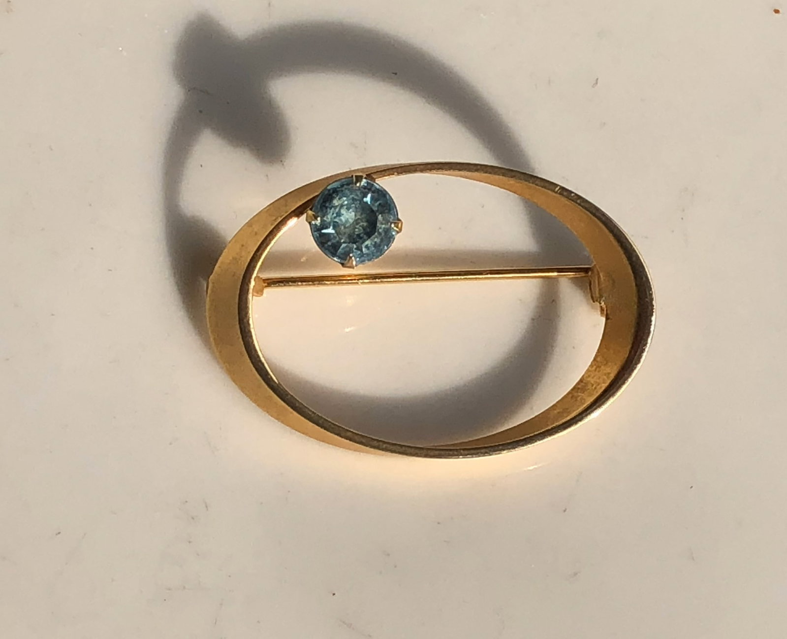 Gold Filled Brooch with Blue Gem: Elegant gold filled brooch featuring a stunning blue gemstone.