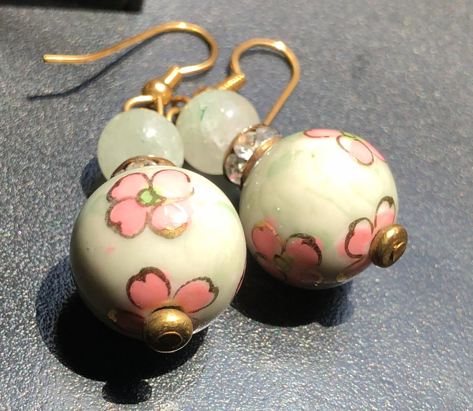 Elegant floral ceramic earrings with pink flower design and gold accents.: Elegant floral ceramic earrings with pink flower design and gold accents.