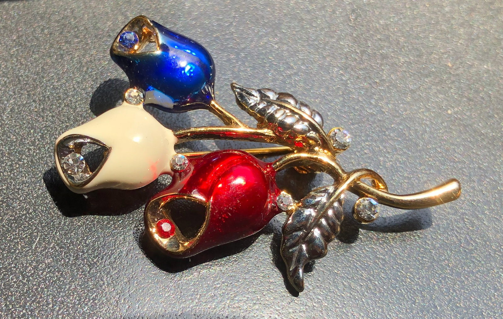 Elegant brooch featuring three enamel flowers in blue, white, and red with crystal accents (1 of 3)