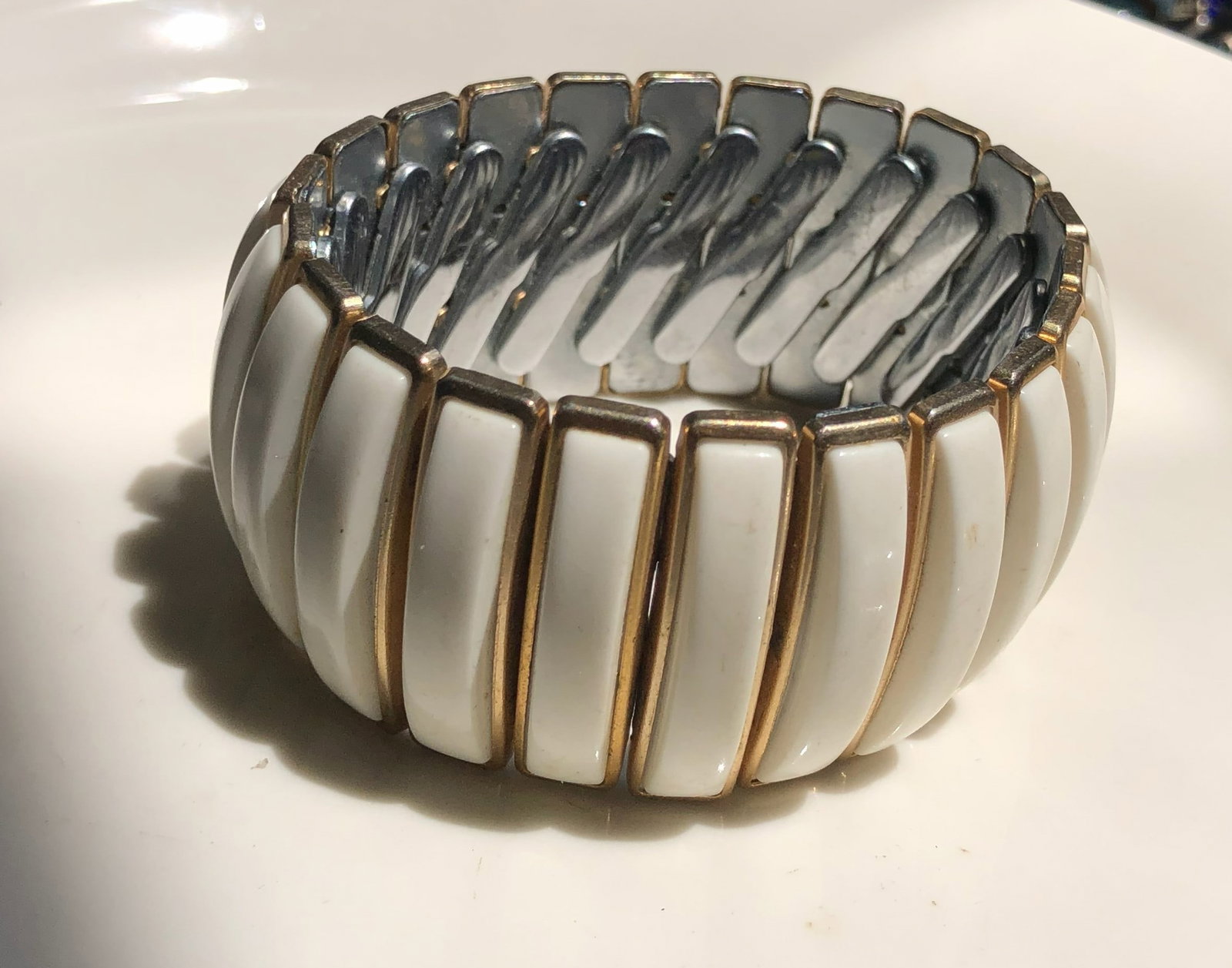 Elegant white and gold color bracelet with a sleek design.
