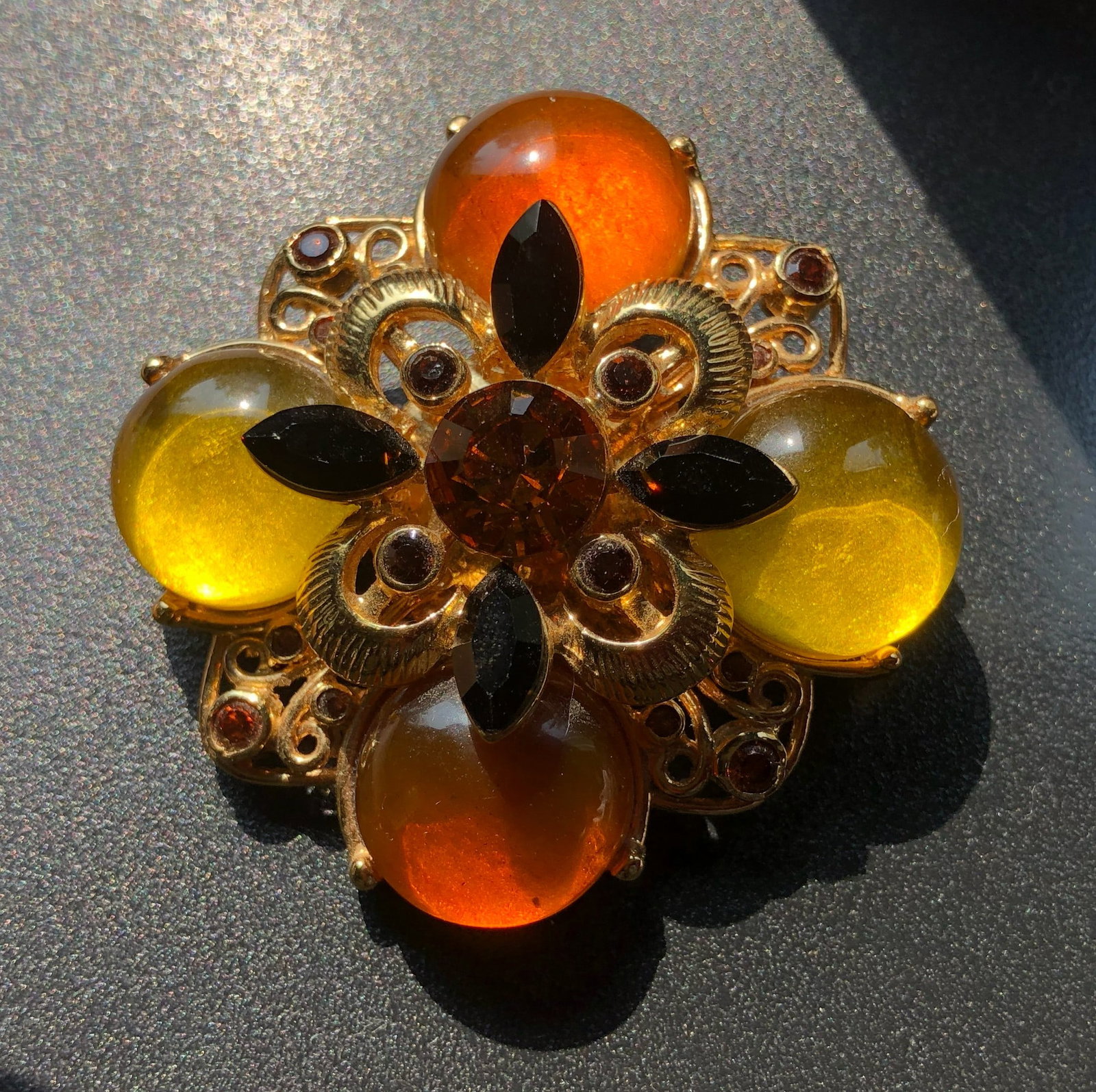 A beautifully crafted vintage brooch featuring amber color stones and intricate gold detailing: A beautifully crafted vintage brooch featuring amber color stones and intricate gold detailing