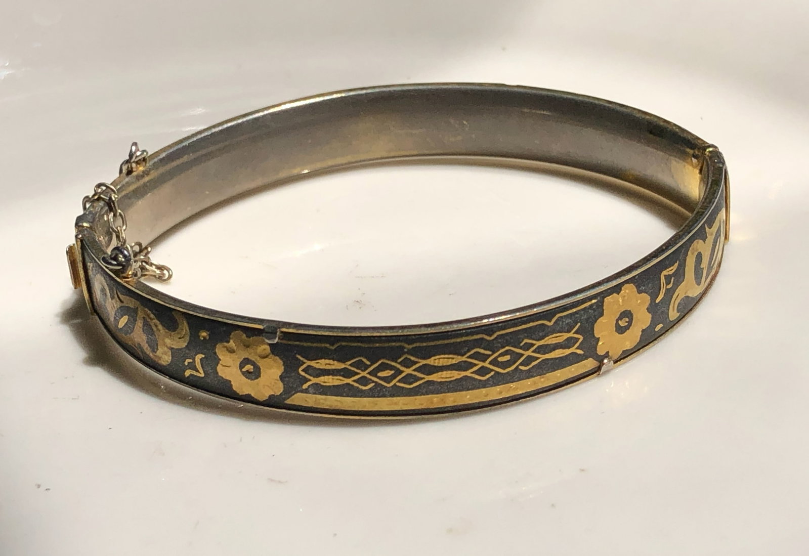 A beautifully crafted vintage bracelet with intricate gold color and black designs: A beautifully crafted vintage bracelet with intricate gold color and black designs