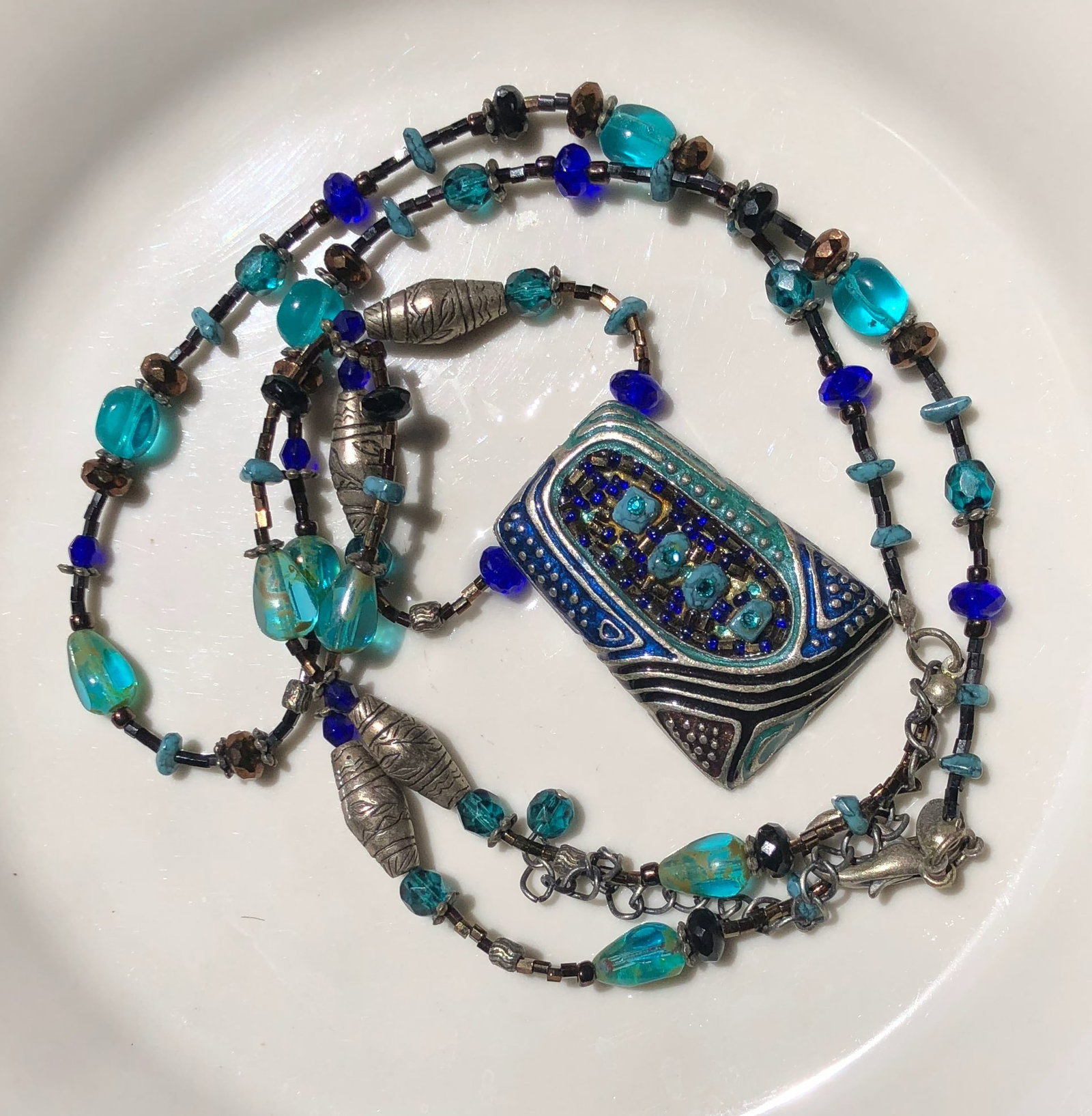 A beautiful handcrafted necklace featuring blue and turquoise beads with intricate metal accents