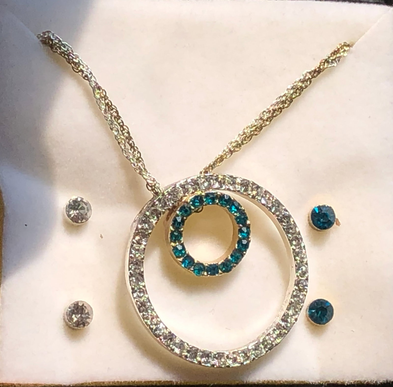A stunning necklace set featuring a double circle pendant adorned with sparkling stones and matching