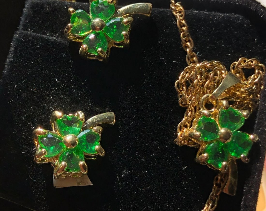 A beautiful jewelry set featuring green gemstones in a floral design, including a necklace and
