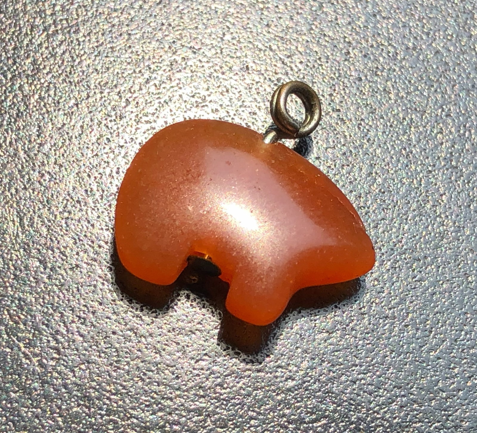 A handcrafted bear-shaped pendant made from Carnelian