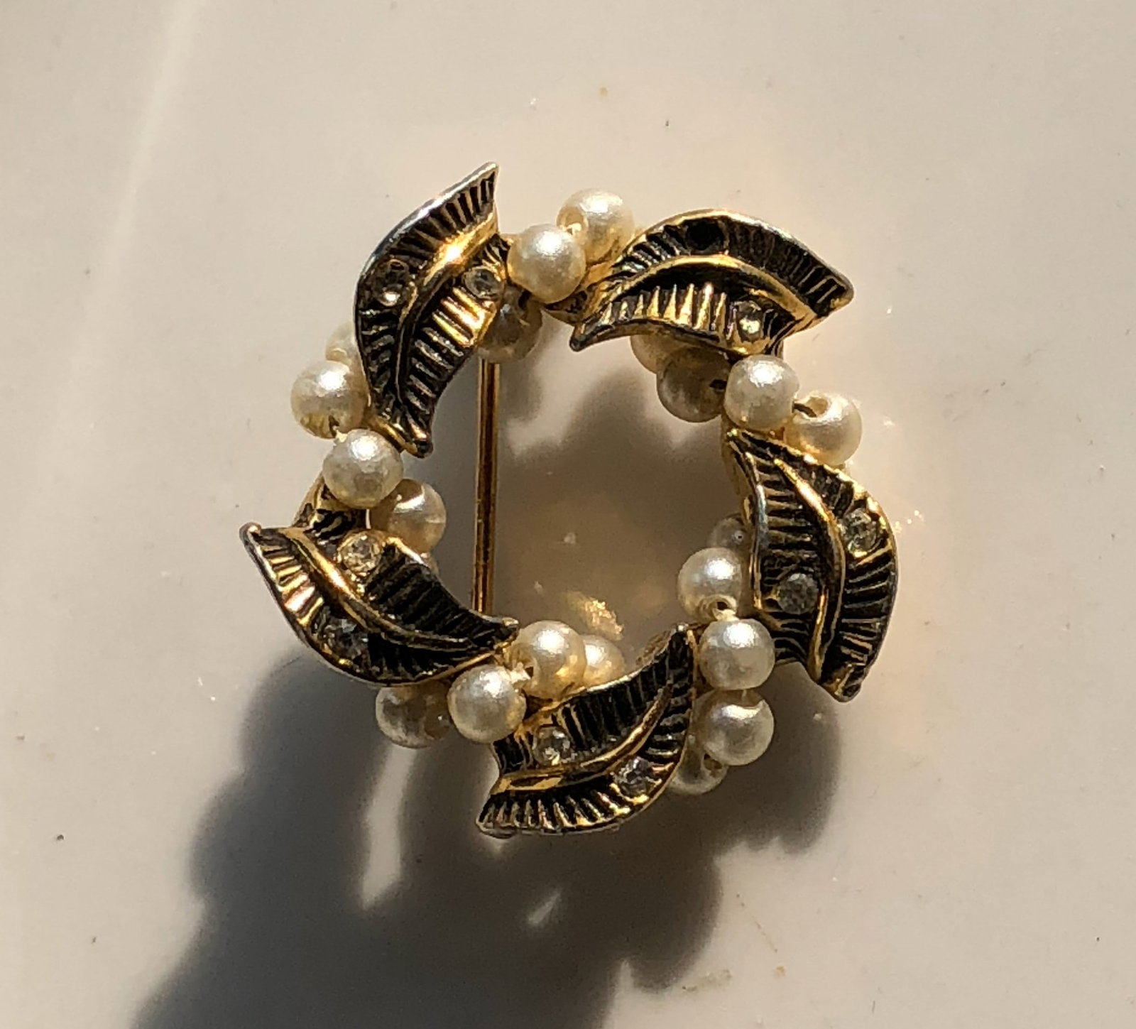 Vintage Leaf and Pearl Brooch: A beautiful vintage brooch featuring intricate leaf designs and elegant pearls.