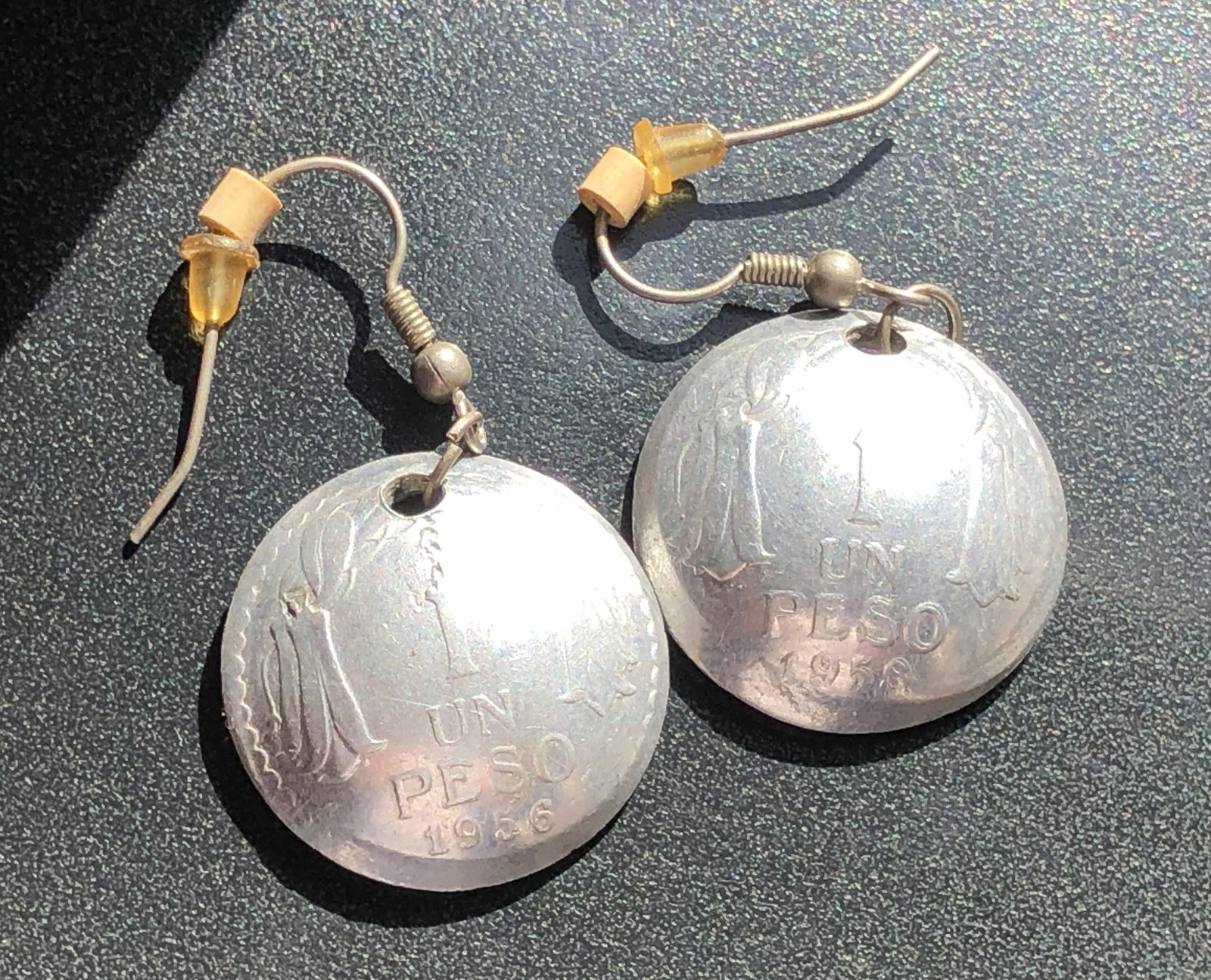 Pair of 1936 Chilean One Peso Silver Coin Earrings: Pair of dangle Silver earrings from Chilean one-peso coins dated 1936, fitted with shepherd-hook ear wires and displaying age-related surface wear and patina.