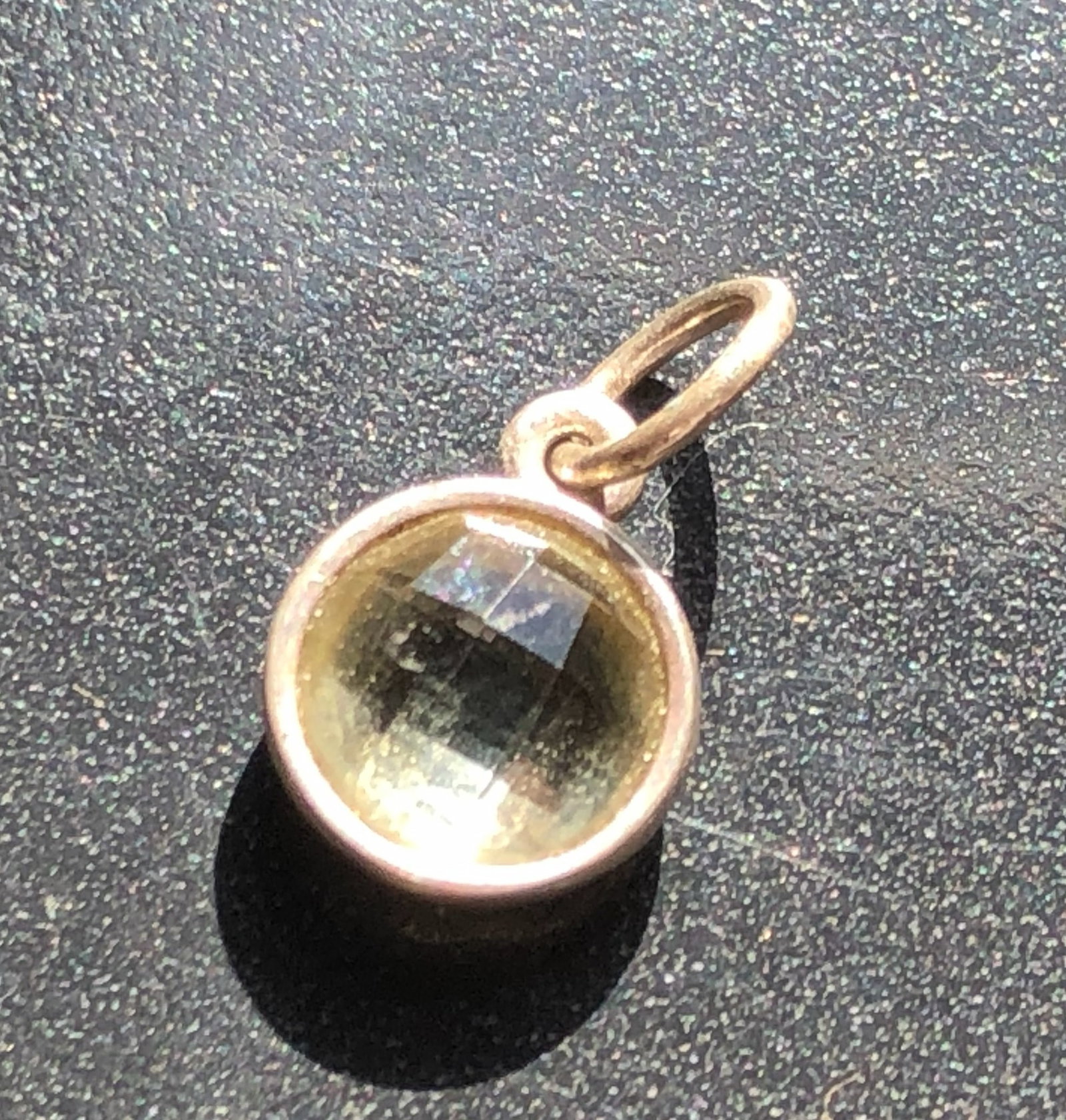Faceted Yellow-Green Stone Silver Pendant: Small round Silver pendant or charm set with a faceted transparent yellow-green stone in a gold-tone bezel, tested Silver