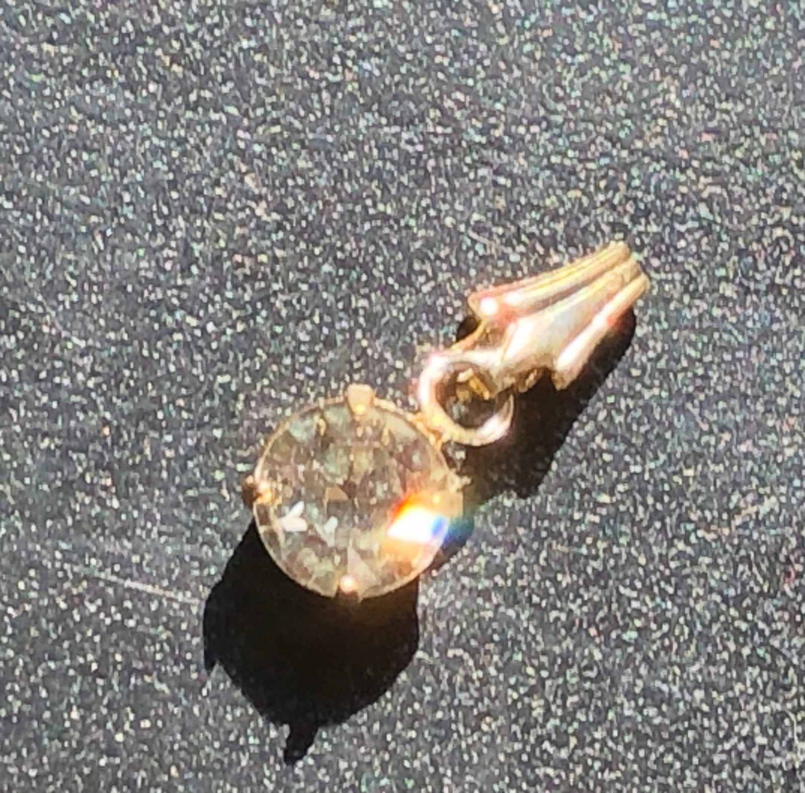 Clear Solitaire Stone Pendant: Petite pendant featuring a round clear faceted stone in a simple prong-style setting with a tapered bail, with gemstone and metal content untested.