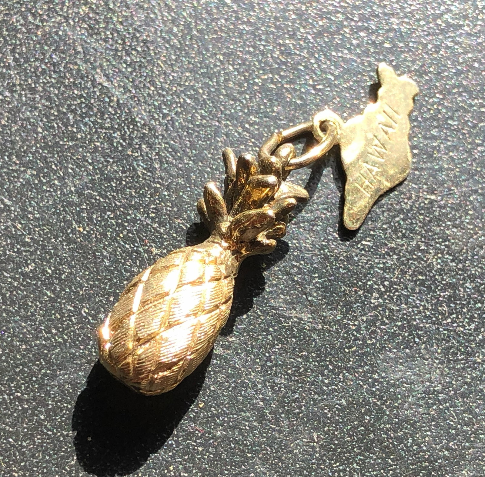 Gold-Tone Pineapple Charm: Small gold-tone pineapple charm with a textured diamond-patterned body and leafy crown, showing light surface wear consistent with previous use.