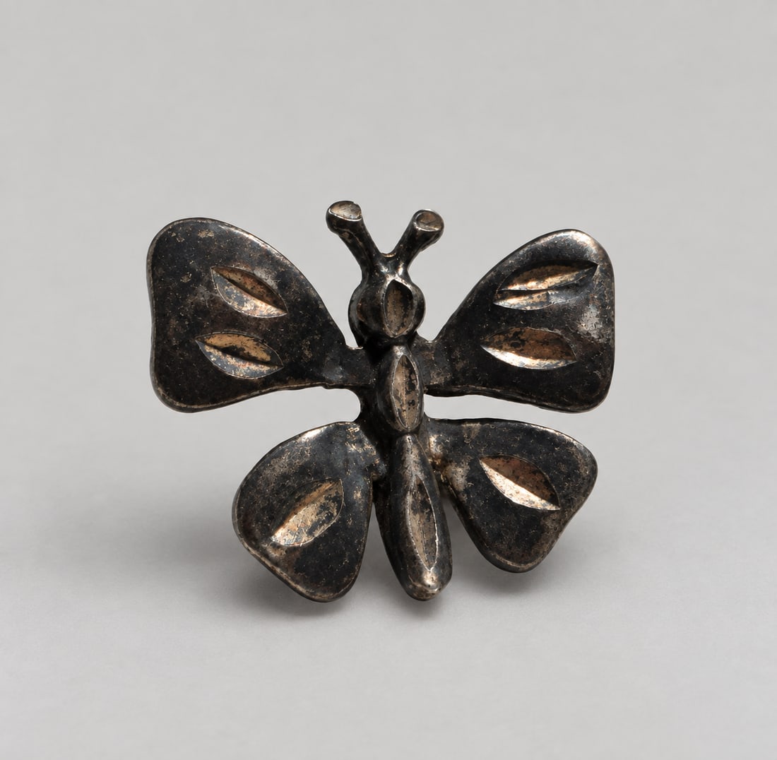 Silver Butterfly Pendant: A sculptural Silver butterfly brooch or charm with open leaf-shaped wing details and substantial age-related patina