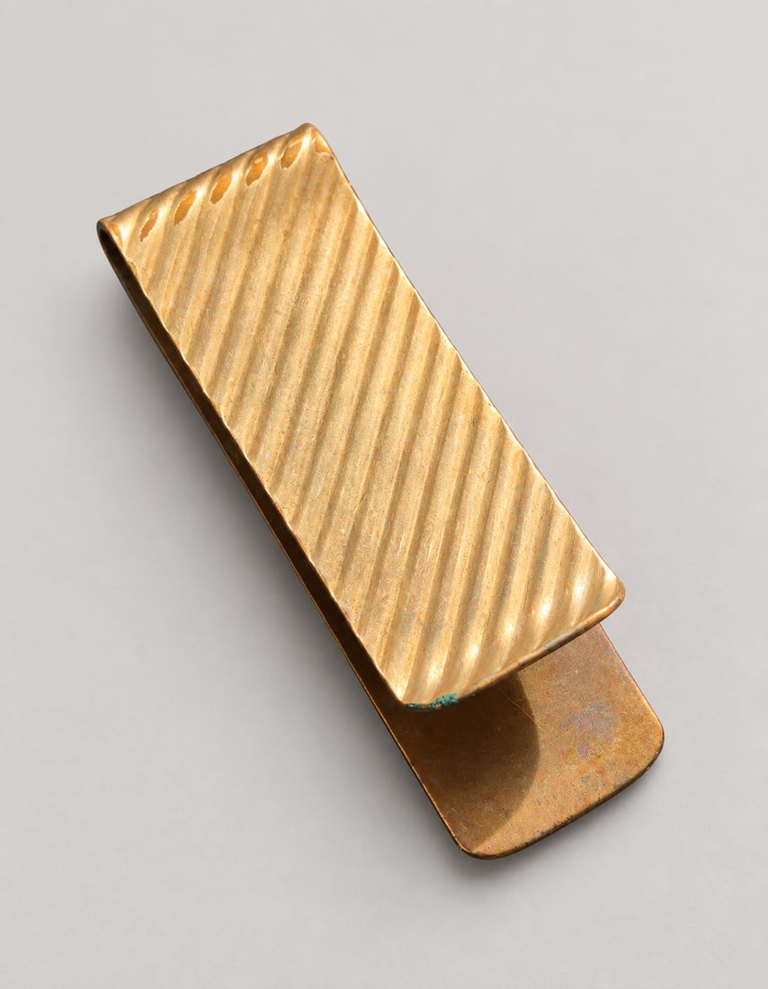 Ribbed Gold-Tone Money Clip: A rectangular gold-tone money clip with a diagonal ribbed face and smooth folded back