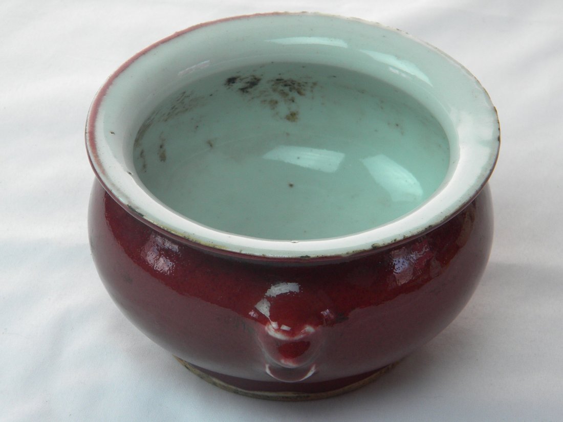 ANTIQUE CHINESE OX BLOOD GLAZED RED INCENSE BURNER QING: ANTIQUE CHINESE OX BLOOD GLAZED RED INCENSE BURNER, QING PERIOD, SIZE: L: 6", DIA: 5", H: 3". FOO DOG EARS ON EACH SIDE.