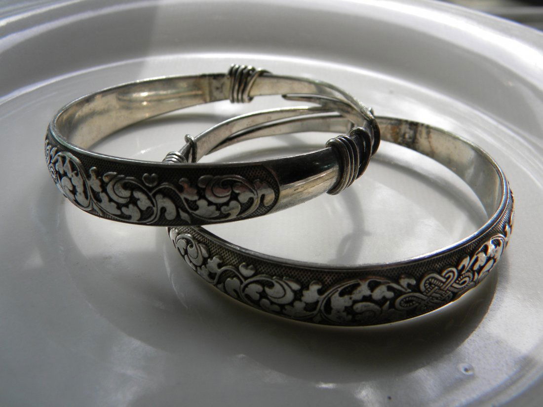 PAIR OF ANTIQUE CHINESE SILVER BRACELETS: PAIR OF ANTIQUE CHINESE SILVER BRACELETS, WITH FLORAL PATTERN ON THE SURFACE, INSIDE DIA: 2.5"