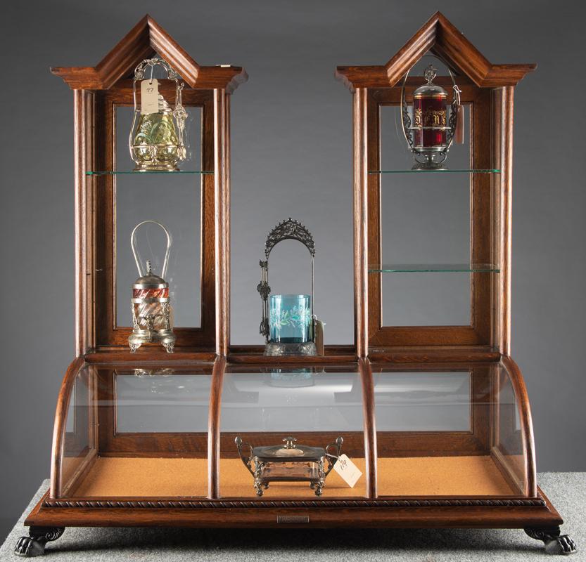 Unique oak & curved glass, double cathedral, footed: Unique oak & curved glass, double cathedral, footed table top model Showcase with bronze label marked "J.W. Winchester & Co." Case is approximately 38" W x 21" D x 40" T. Showcase has three door rear 