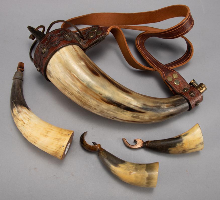 Group of four Steer Horn items, to include: (1) Horn: Group of four Steer Horn items, to include: (1) Horn Powder Flask with tooled leather strap, horn measures 12" long. (2) A small Powder Flask with wooden tip, 8" long. (3) Two horn Bottle Openers with
